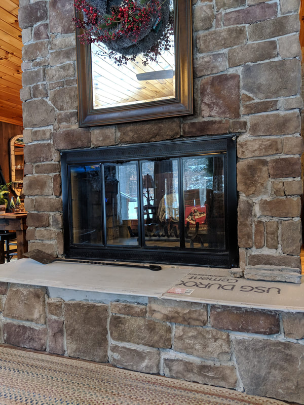two sided fireplace with broken doors and hearth